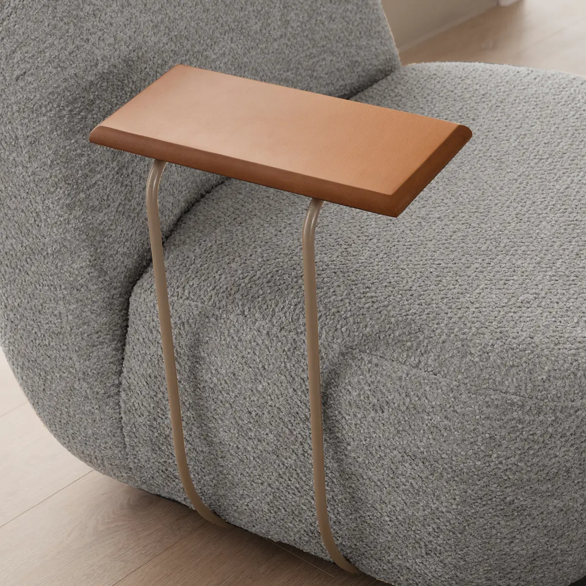 Close-up of the Olissa armchair wooden side tray resting on grey bouclé upholstery – Asbar Furniture